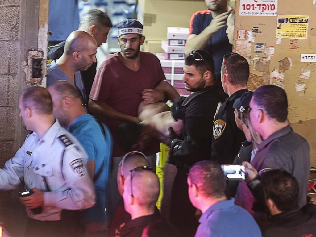 Israeli policemen arrest a Palestinian attacker at the scene of a stabbing attack in Tel Aviv Israel. Two people were killed and a third injured by an assailant wielding a knife