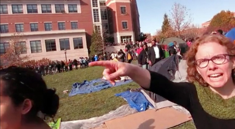 In this Nov. 9 2015 frame from video provided by Mark Schierbecker Melissa Click right an assistant professor in Missouri's communications department confronts Schierbecker and later calls for'muscle to help remove him from the protest area in Colu