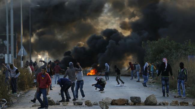 Palestinian protesters throw stones toward Israeli forces during clashes at the entrance of the Palestinian city of al-Bireh which lies on the outskirts of Ramallah in the Israeli-occupied West Bank