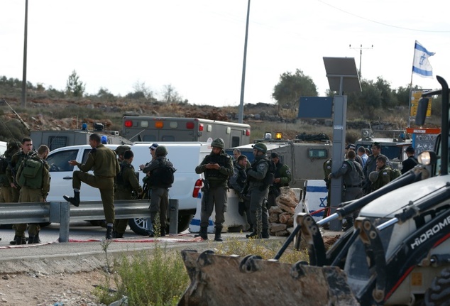 Israeli security forces stand guard at the site of a stabbing attack at Tapuah junction south of Nablus in the West Bank