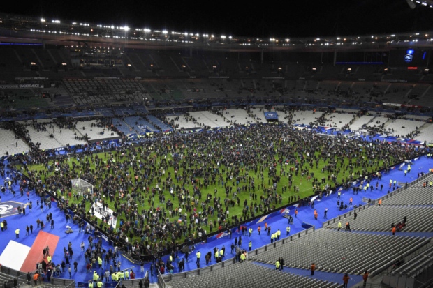 Spectators gather on the pitch following the match