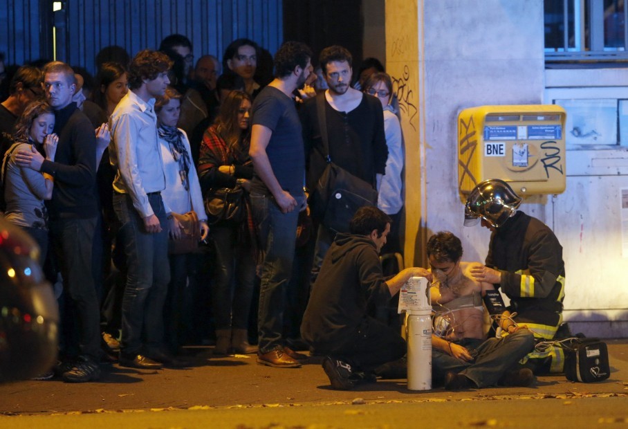 ATTENTION EDITORS- VISUAL COVERAGE OF SCENES OF INJURY OR DEATH A member of the French fire brigade aids an injured individual near the Bataclan concert hall following fatal shootings in Paris France