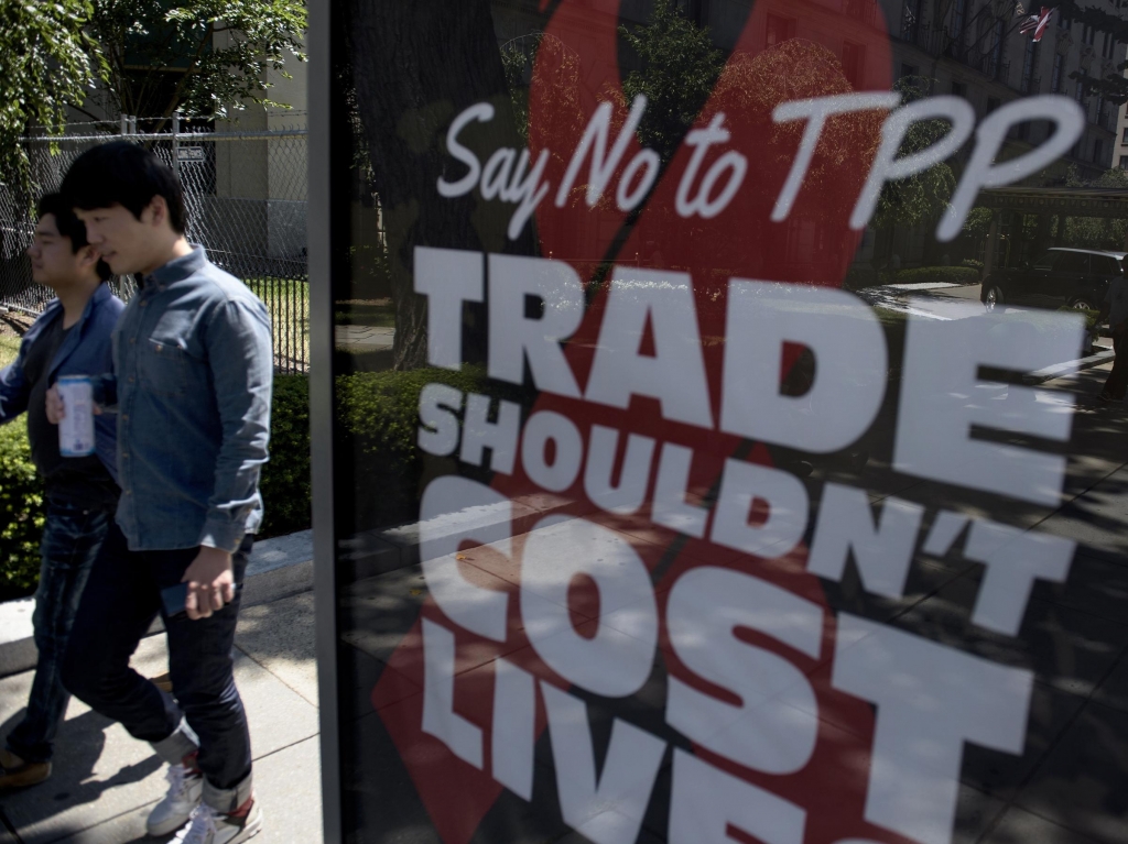 Passersby in Washington D.C. walk near an ad protesting the Trans Pacific Partnership in July