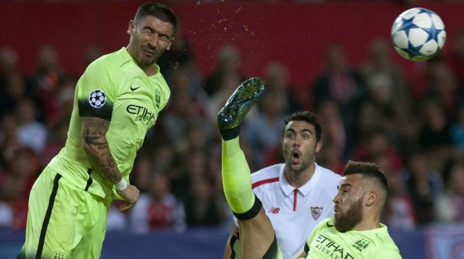 Manchester City defenders Aleksandar Kolarov and Nicolas Otamendi vies with Sevilla midfielder Vicente Iborra during the UEFA Champions League football match Sevilla FC vs Manchester City. AFP