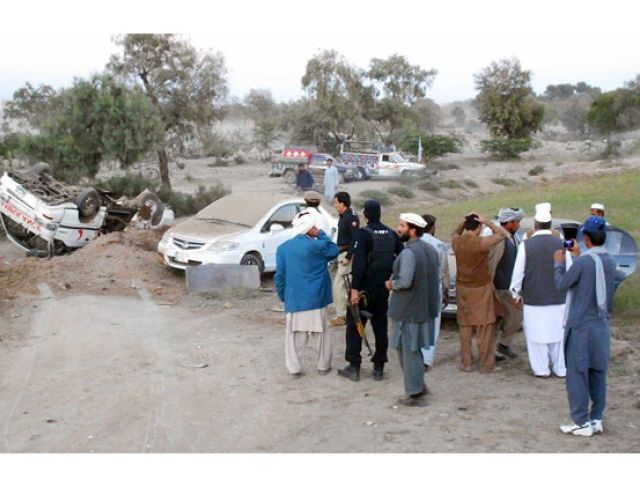 People and security seen at the site of attack on convoy of Federal housing and works minister and JUI-F leader Akram Khan Durrani