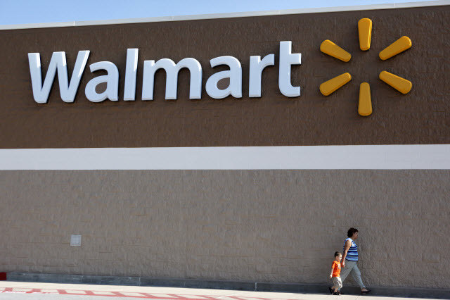 People are walking past a Walmart sign outside a store in Arkansas