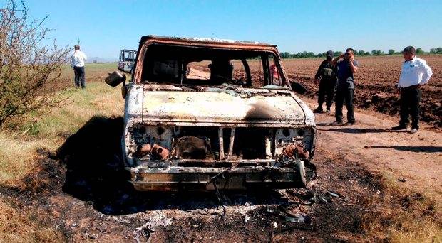 Mexican authorities inspect a burnt out van suspected to belong to a couple of Australian tourists missing for more than a week in Sinaloa Mexico