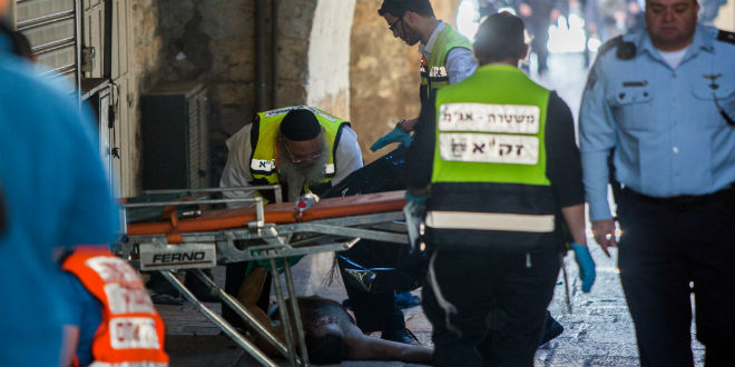 Israeli security forces and ZAKA personnel near the body of a terrorist at the scene of a stabbing attack in Jerusalem's Old City