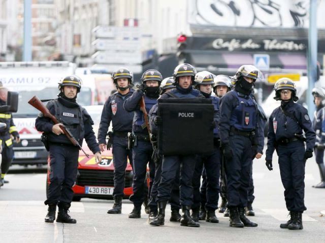 Policemen stand guard in Paris as special forces raid an apartment