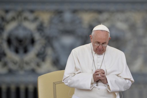 Pope Francis prays during his weekly general audience at St Peter's square