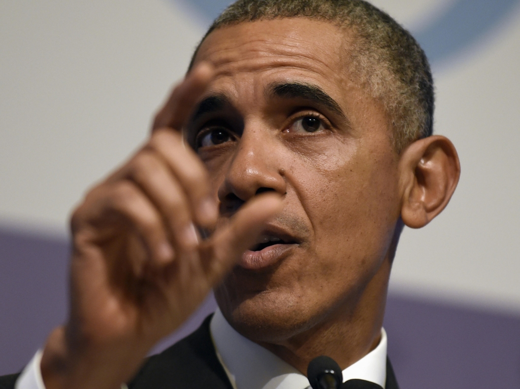 President Barack Obama speaks on the phone in the Oval Office while Denis Mc Donough looks