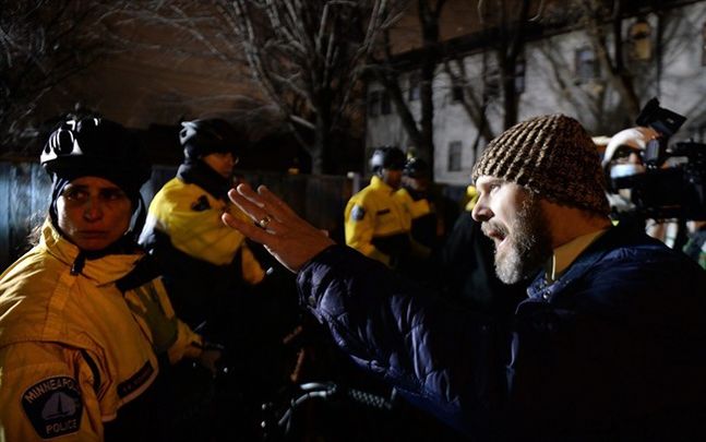 Pastor Tanden Brekke right pleads with police officers to de-escalate the situation as demonstrators besiege the Minneapolis Police Department Fourth Precinct building in Minneapolis on Wednesday Nov. 18 2015. Protesters have been camping outside the