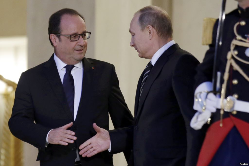 French President Francois Hollande shakes hands with Russian President Vladimir Putin after a summit on the Ukraine crisis at the Elysee Palace in Paris France on October 2