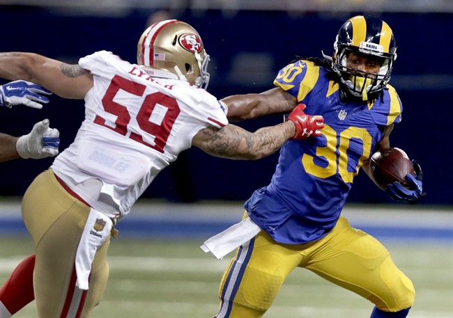 St. Louis Rams running back Todd Gurley right runs with the ball as San Francisco 49ers outside linebacker Aaron Lynch defends during the third quarter of an NFL football game Sunday Nov. 1 2015 in St. Louis