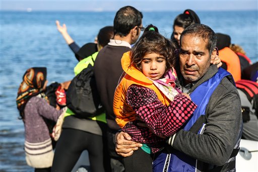 A man holds a girl after their arrival on a dinghy from the Turkish coast to the Skala Sikaminias village on the northeastern Greek island of Lesbos on Wednesday Nov. 11 2015. More than 770,000 people have arrived in the EU by sea so far this year overw