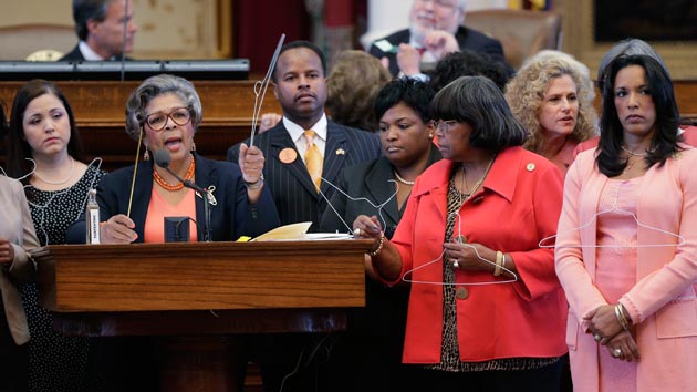 Rep. Senfronia Thompson and other Texas representatives hold coat hangers while discussing HB2 an anti-abortion bill. Eric Gay  AP