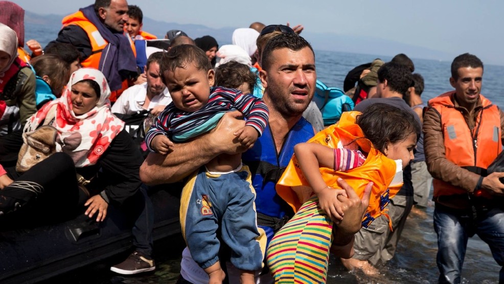 Syrian refugees arrive aboard a dinghy after crossing from Turkey to the island of Lesbos Greece