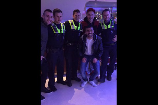 Boys in blue Police pose with the Roma man