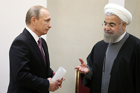 Iran's President Hassan Rouhani right makes his way to shake hands with Russian President Vladimir Putin