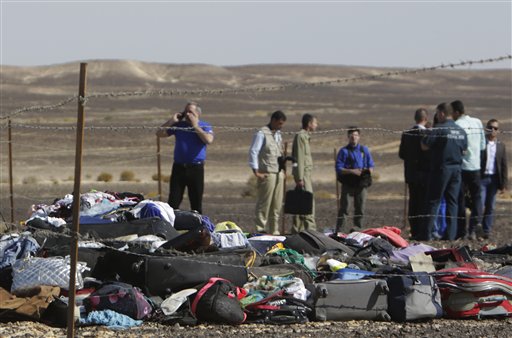 Russian investigators stand near debris luggage and personal effects of passengers a day after a passenger jet bound for St. Petersburg in Russia crashed in Hassana Egypt on Sunday Nov. 1 2015. The Metrojet plane crashed 23 minutes after it took off