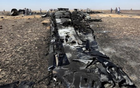 Military investigators from Egypt and Russia stand near the debris of a Russian airliner at the site of its crash at the Hassana area in Arish city north Egypt