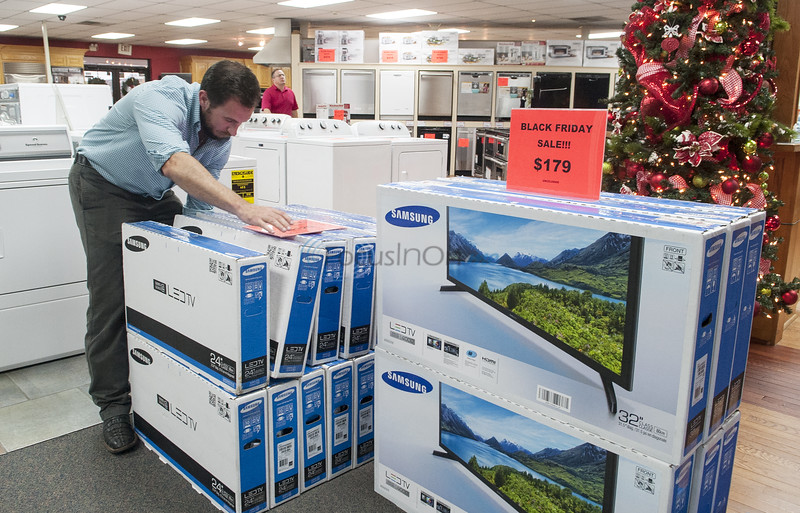 Sales associate Chris Smith organizes a television display Friday at Dons TV & Appliance in Tyler