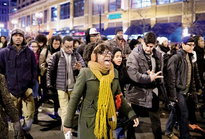 Several hundred people blocked traffic and circled police cars and chanted “16 shots.” Pics  AFP