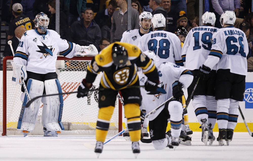 The Sharks’ Martin Jones left stands in the net as the Bruins’ David Krejci foreground center skates away while the Sharks celebrate their 5-4 win over Boston on Tuesday night