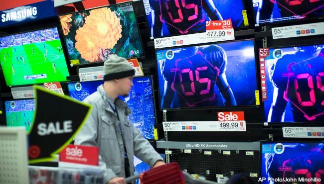 A holiday shopper browses the electronics section against a backdrop of televisions at a Target store Friday Nov. 27 2015 in Newport Ky