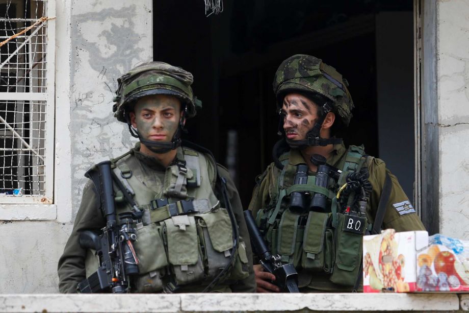 Israeli soldiers stand outside a Palestinian house during a search near the Tel Rumeida settlement in the West Bank city of Hebron Saturday Nov. 7 2015. Three assaults took place Friday in Hebron the West Bank's largest city which has been the main