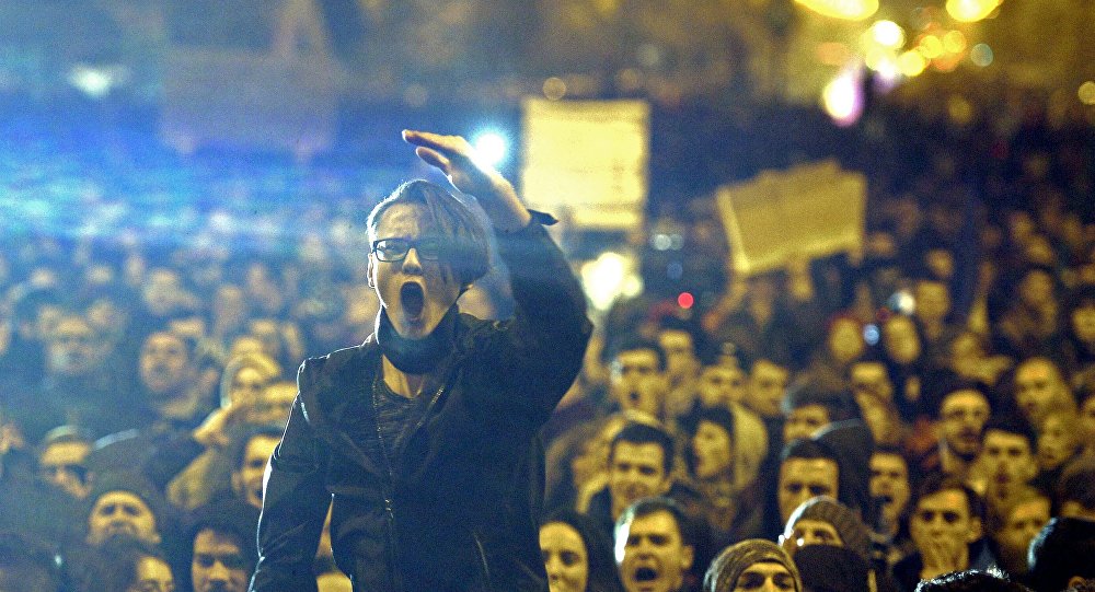 A demonstrator shouts anti corruption slogans during a street protest in Bucharest Romania