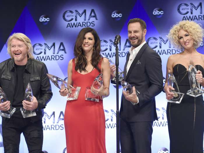 Phillip Sweet from left Karen Fairchild Jimi Westbrook and Kimberly Schlapman of Little Big Town winners of the awards for vocal group of the year and single of the year for'Girl Crush' pose in the press room at the 49th annual CMA Awards at the Br