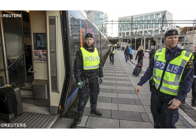 Swedish police check an incoming train on the border between Sweden and Denmark.- REUTERS