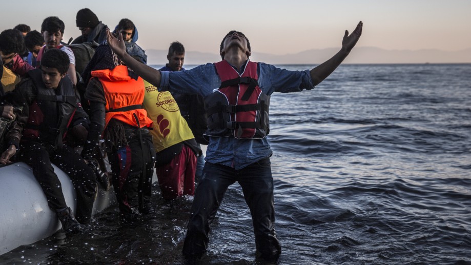 A young man gestures after disembarking from a dinghy at a beach on the Greek island of Lesbos after crossing the Aegean sea from the Turkish coast Saturday More than 810,000 people have crossed the Mediterranean this year over 200,000 in October alone
