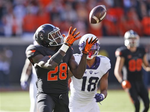 Oklahoma State wide receiver James Washington catches a pass in front of TCU safety Nick Orr and carries it in for a touchdown in the first quarter of an NCAA college football game in Stillwater Okla. Saturday Nov. 7 2015. (AP