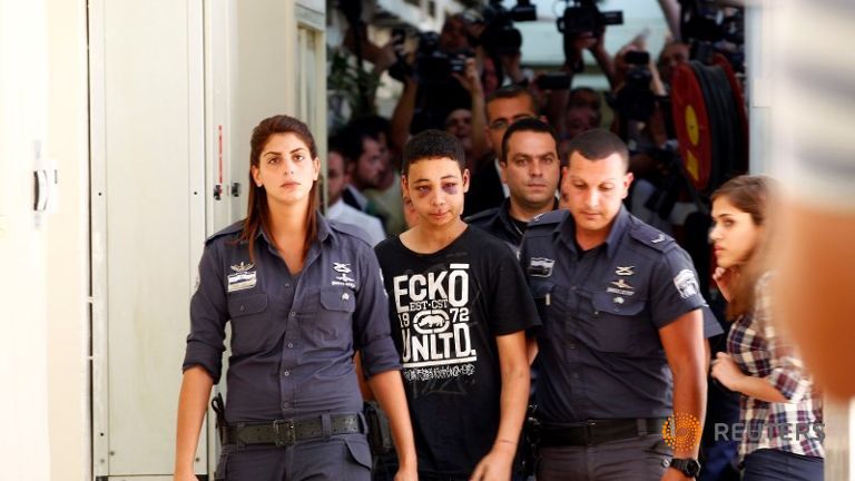 Tariq Khdeir an American of Palestinian descent is escorted by Israeli prison guards during an appearance at Jerusalem magistrate's court