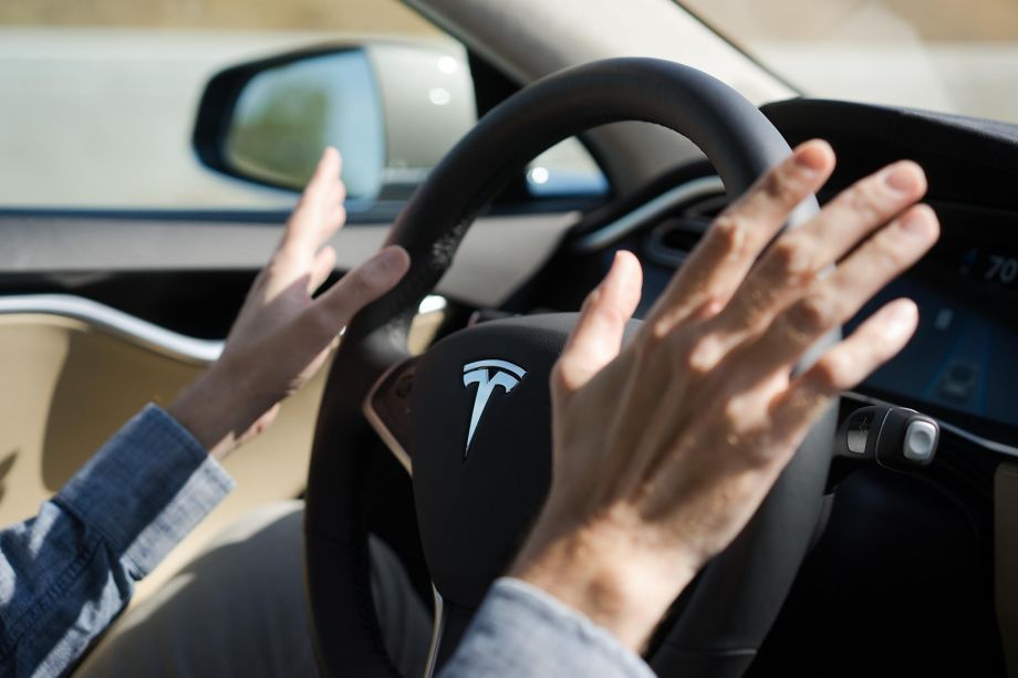 San Francisco Chronicle Reporter David Baker takes his hands off the steering wheel as the Tesla drives in autopilot in Palo Alto Calif. on Wednesday Oct. 14 2015. An update to Tesla's Autopilot system will aide drivers in changing lanes parking and