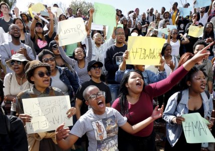 A student holds up a sign that reads