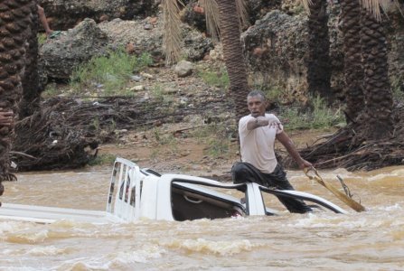 A man gestures as he tries to save a vehicle swept away by flood waters in Yemen's island of Socotra