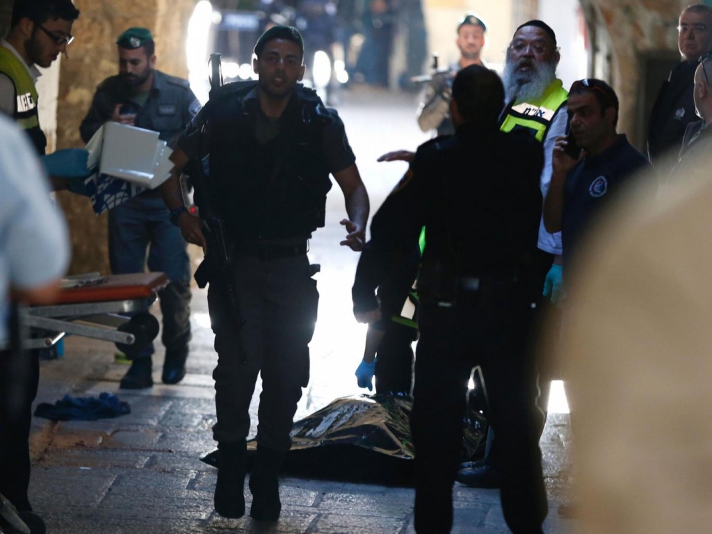 Israeli officials next to body of Palestinian man killed