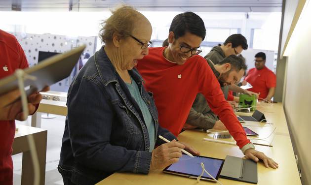 Stamets left of Carmichael Calif. gets assistance from Cesar Cedano while trying the Apple iPad Pro at the Apple store Friday Nov. 13 2015 in San Francisco. The iPad Pro starts at $799 compared with $499 for the standard-size iPa