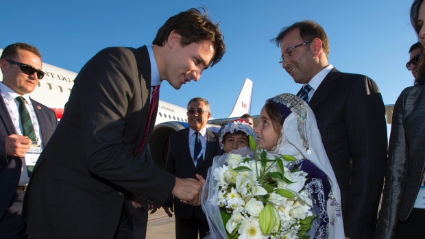 Prime Minister Justin Trudeau is presented with flowers as he arrives in Antalya Turkey to take part in the G20 summit