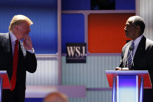 Republican U.S. presidential candidate and businessman Donald Trump whispers across to Dr. Ben Carson during a debate held in Milwaukee Wis. Nov. 10 2015