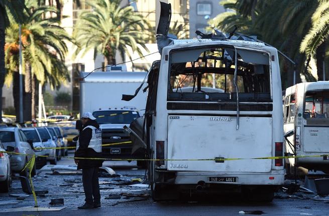 Tunisian police inspect the bombed bus