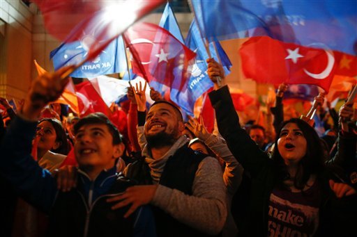 Supporters of Turkey's President Recep Tayyip Erdogan and The Justice and Development Party  wave their party and national flags as they celebrates outside the AKP headquarters in Istanbul Sunday Nov. 1 2015. Tens of millions of Turkish voters