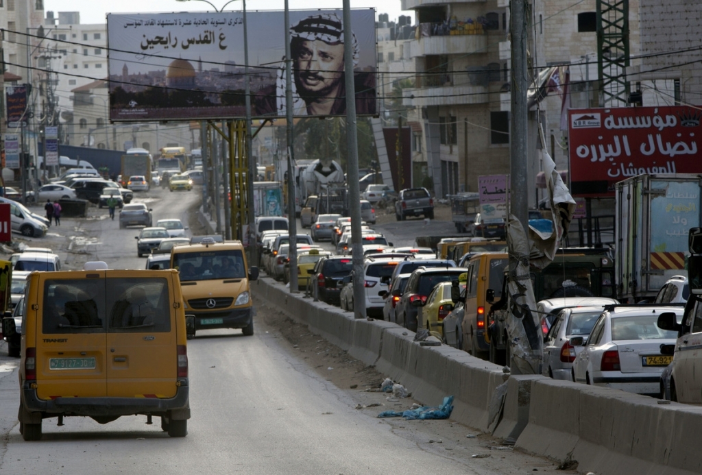 Palestinians drive near the Qalandia checkpoint between Jerusalem and the West Bank city of Ramallah. A pair of new mobile apps hopes to help Palestinians navigate their way around snarled traffic at Israeli checkpoin