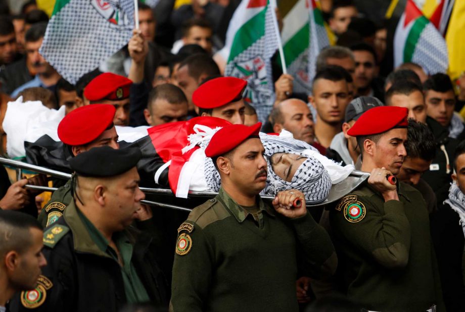 Palestinian security officers carry the body of 16-year-old Ibrahim Dawood during his funeral in the West Bank city of Ramallah Thursday Nov. 26 2015. Ibrahim died of his wounds sustained during clashes with Israeli soldiers two weeks ago near Beit El