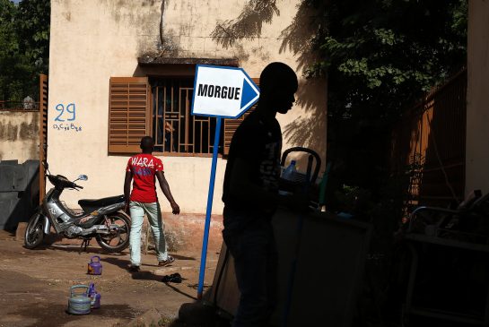 Hospital workers walk outside the morgue of the Gabriel Toure hospital in Bamako Mali Sunday Nov. 22 2015. The heavily armed Islamic extremists who shot up a luxury hotel in Mali's capital killing 19 people timed their assault for the moment when