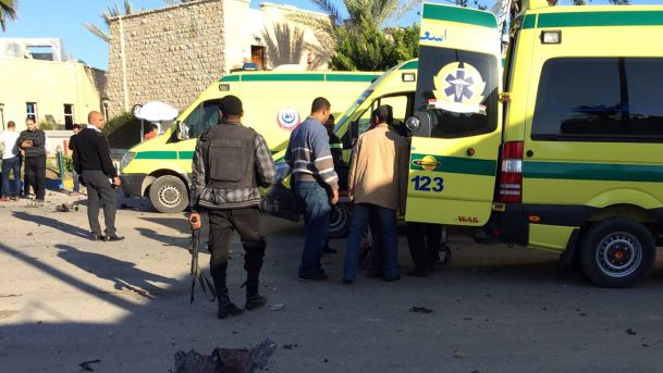 Emergency personnel and security forces stand next to ambulances outside the Swiss Inn hotel in the Egyptian town of El-Arish in the Sinai peninsula following an attack on the hotel by two suicide bombers and a gunman