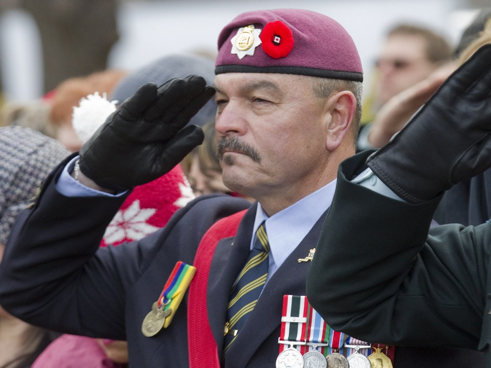 Canadian Army veteran Tracy Cross salutes during the Canadian National anthem during a Remembrance Day ceremony at Mc Gill University in Montreal Wednesday